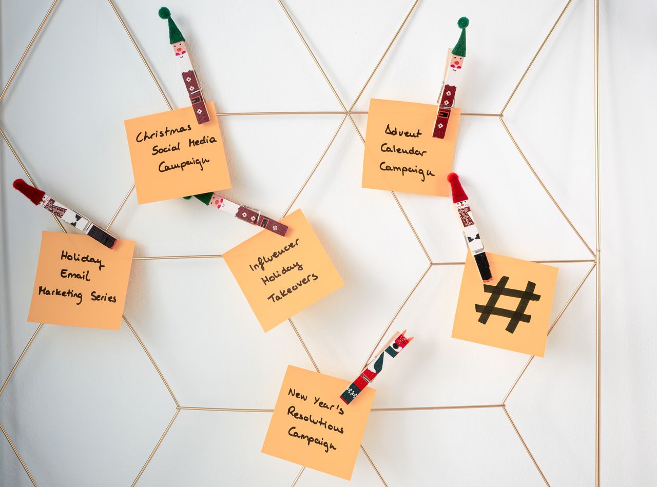 Notes adhésives avec des idées de marketing pour les fêtes, fixées à une grille murale.